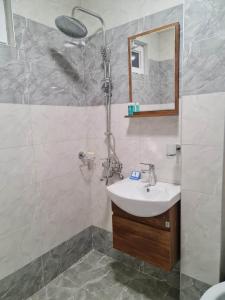 y baño con lavabo y ducha. en Saburtalo en Tiflis