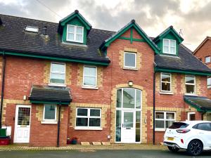 una casa di mattoni rossi con una macchina bianca parcheggiata di fronte di Harland View Apartment a Belfast