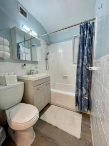 a bathroom with a toilet and a sink and a tub at Renovated guest house in Hyattsville