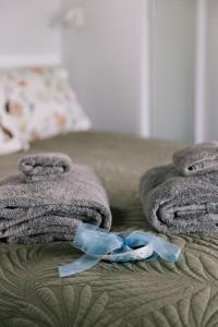 a pair of towels and a blue ribbon on a bed at Birds Eye View in Havelock North
