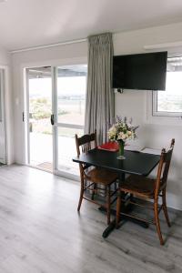 uma sala de jantar com uma mesa e cadeiras e uma janela em Birds Eye View em Havelock North