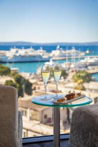 twee wijnglazen op een tafel met uitzicht op de oceaan bij Hotel Luxe in Split