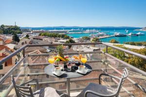 een tafel op een balkon met uitzicht op het water bij Hotel Luxe in Split