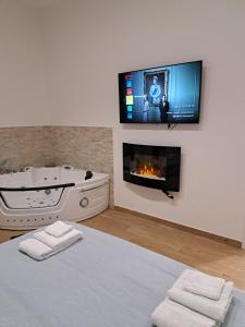 a room with a tub and a tv on a wall at Vient' e mar suite in Castellammare di Stabia