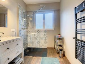 a bathroom with a shower with a window and a sink at Aux Magnolias, Maison proche Colmar et Munster in Zimmerbach