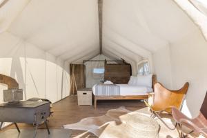 a bedroom with a bed in a tent at Under Canvas North Yellowstone - Paradise Valley in Livingston