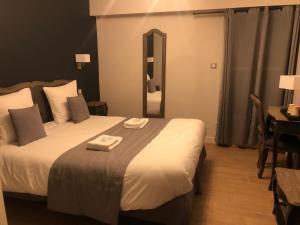 une chambre d'hôtel avec un lit et 2 serviettes. dans l'établissement Château de Petit Bois, à Cosne-dʼAllier