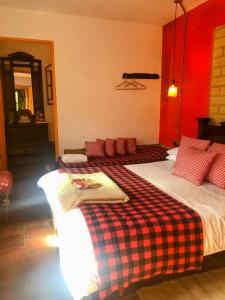 1 Schlafzimmer mit 2 Betten und einer karierten Decke in der Unterkunft Mi Casa es tu Casa Inn in Chiquinquirá