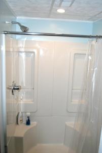 a white bathroom with a shower and a sink at Hoosier Inn- Indiana University in Bloomington