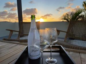 a bottle of wine and two glasses on a tray at Belnem Seaview Rooftop in Kralendijk