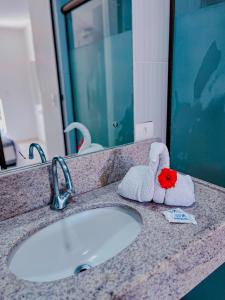 a bathroom counter with a sink with towels on it at Mar a Vista in Porto De Galinhas