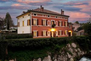 a large house with a sunset in front of it at il loggiato 1 in Castelfranco Veneto