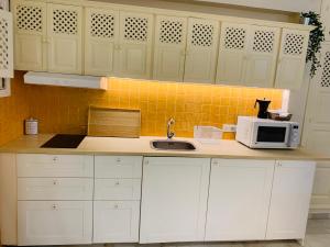 a kitchen with white cabinets and a sink and a microwave at Lovely studio in Marbella close to Puente Romano in Marbella