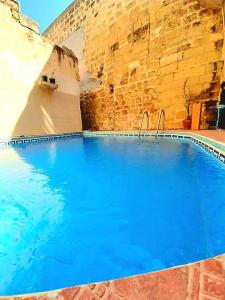 a large swimming pool with blue water in a building at Ta lucia farmhouse with private pool and BBQ in Santa Luċija