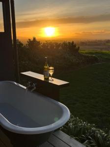 a bath tub with a bottle and two glasses of wine at Birds Eye View in Havelock North