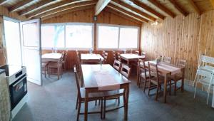 a dining room with tables and chairs and windows at Bebalkan guesthouse in Raduil