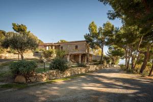 an old house with a stone wall and trees at Masseria Agriturismo Torre Di Albidona in Trebisacce