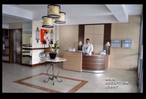 a man standing at a counter in a kitchen at Marquinton Place City View in Manila