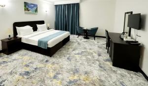 a hotel room with a bed and a television at Al Massa Hotel in Al Ain