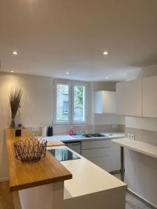 a kitchen with white cabinets and a counter top at Super appartement refait à neuf beaucoup de charme in Boulogne-Billancourt