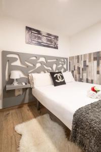 una camera con un grande letto bianco e un tappeto di Apartamentos Day Madrid BEATAS Centro Gran Via Sol Malasaña a Madrid