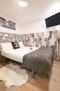una camera con un letto con una coperta bianca e nera di Apartamentos Day Madrid BEATAS Centro Gran Via Sol Malasaña a Madrid