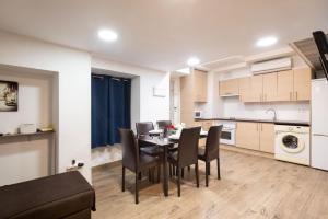 una cucina e una sala da pranzo con tavolo e sedie di Apartamentos Day Madrid BEATAS Centro Gran Via Sol Malasaña a Madrid