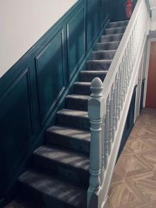 a staircase with blue walls and white railings at 2 Bed fully furnished apartment in Cookstown