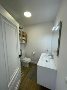 a white bathroom with a sink and a toilet at Covelodge - Piso a pocos metros de la playa in Pontevedra