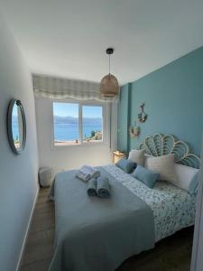 1 dormitorio con 1 cama y vistas al océano en Covelodge - Piso a pocos metros de la playa, en Pontevedra