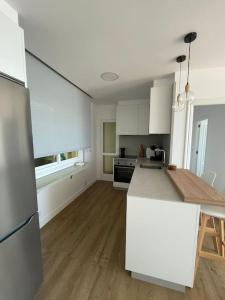 cocina con armarios blancos y encimera blanca en Covelodge - Piso a pocos metros de la playa, en Pontevedra