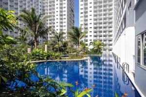 a large swimming pool in a city with tall buildings at simple and affordable staycation in Manila