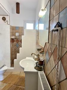 a bathroom with a sink and a toilet and stairs at ALONI G&A Archaggelos in Archangelos