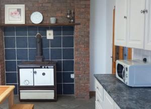 a kitchen with a stove and a microwave at Sarlyn Holiday Home Achill in River