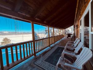 2 sillas en un porche con vistas a la nieve en Balsam Hill Lodge - Sleeps 15, en Island Park
