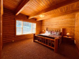 1 dormitorio con 1 cama en una cabaña de madera en Balsam Hill Lodge - Sleeps 15, en Island Park