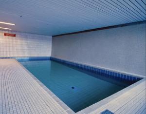 a large swimming pool in a room with blue tiles at Black Forest Style inkl. Sauna und Pool für 2-4 P. in Schönwald