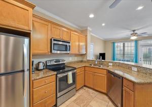 a kitchen with wooden cabinets and stainless steel appliances at The Dawn on Galveston Beach in Galveston