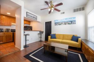 a living room with a yellow couch and a ceiling fan at Charming mini-suite in West Campus! in Austin