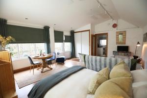1 dormitorio con 1 cama y 1 mesa con sillas en Garden Studio in Biggar en Biggar
