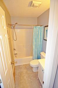 a bathroom with a white toilet and a shower at Waterway Landing Gated Community 2BR Condo in Myrtle Beach