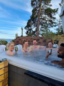 eine Gruppe von Personen in einer Whirlpool-Badewanne in der Unterkunft Nils Bastu Spa och Övernattningstuga in Tyresö