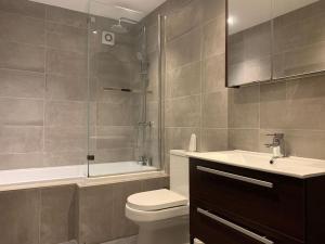 a bathroom with a toilet and a shower and a sink at Fantastic Large 2 X Bedroom Flat, Free Parking in Sale