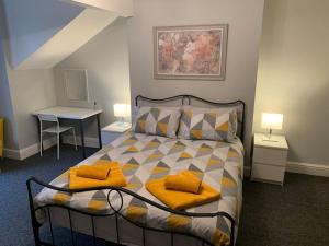 a bedroom with a bed with two yellow pillows on it at Fantastic Large 2 X Bedroom Flat, Free Parking in Sale