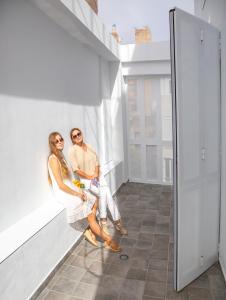 a man and a woman sitting on a ledge in a building at EDI Astoria in Santa Cruz de Tenerife