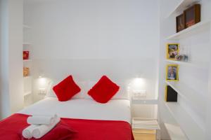 a white bed with red pillows and a red blanket at EDI Astoria in Santa Cruz de Tenerife