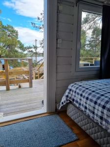 a room with a bed and a door to a porch at Nils Bastu Spa och Övernattningstuga in Tyresö