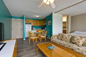 a living room and kitchen with a couch and a table at Royal Kuhio 1602 - Spacious Studio with Stunning Mountain Views in the Heart of Waikiki! in Honolulu