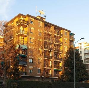 un bâtiment jaune avec un oiseau assis au-dessus dans l'établissement Casa Felice, à Milan