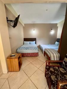a hotel room with two beds and a table at Hotel Catedral in Ciudad del Este